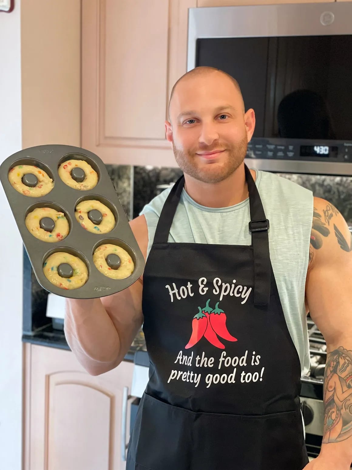 Eitan holding a full tray of freshly-baked protein donuts